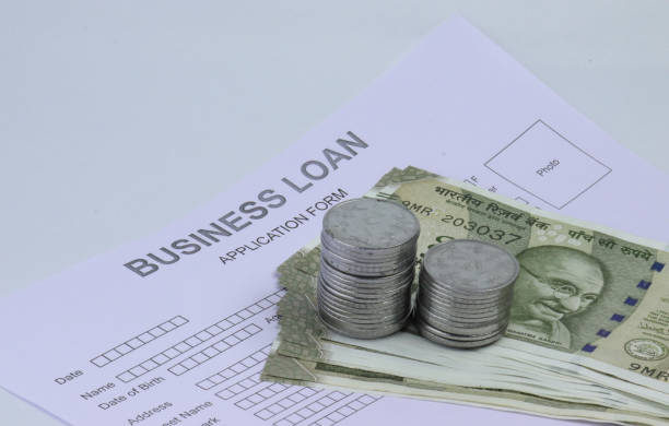 Services business loan application form and indian notes and coins.