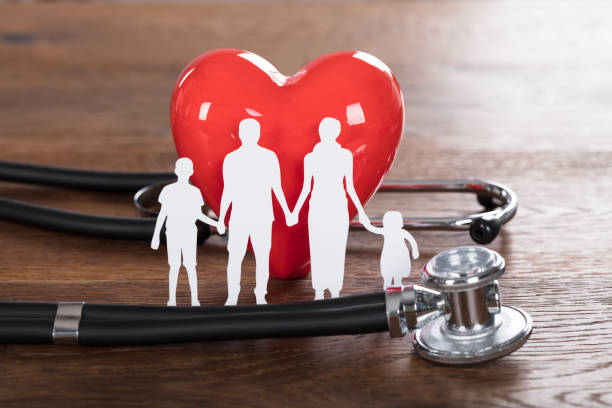 Services medical insurance concept with family cut out and stethoscope on wooden desk